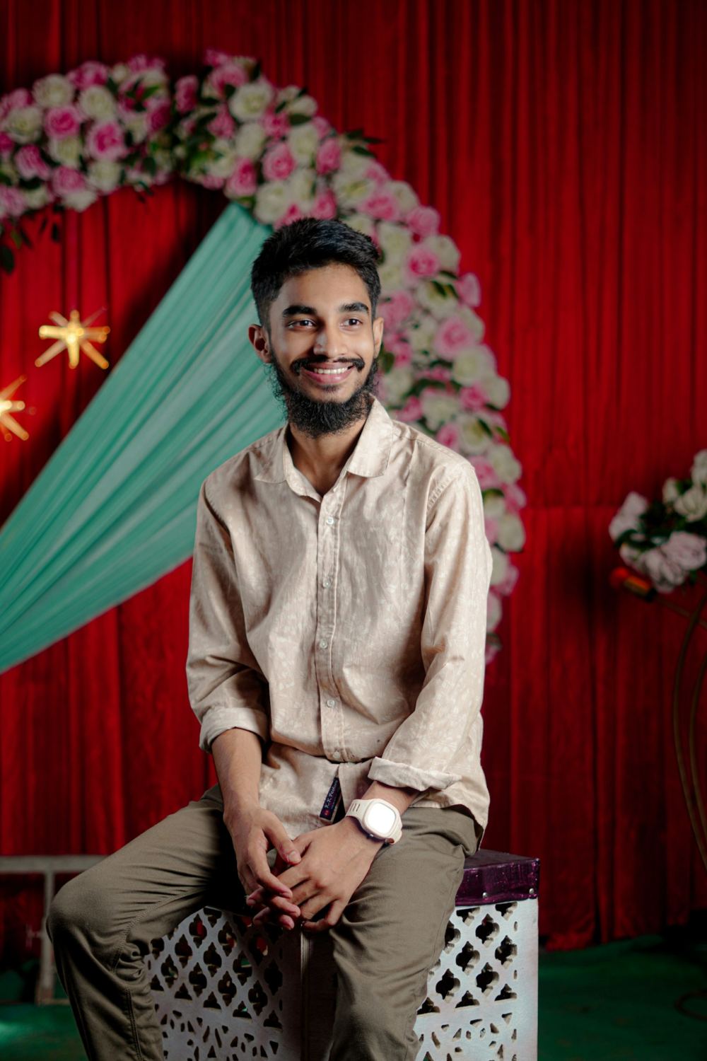 Guest seated in front of a floral photo booth backdrop