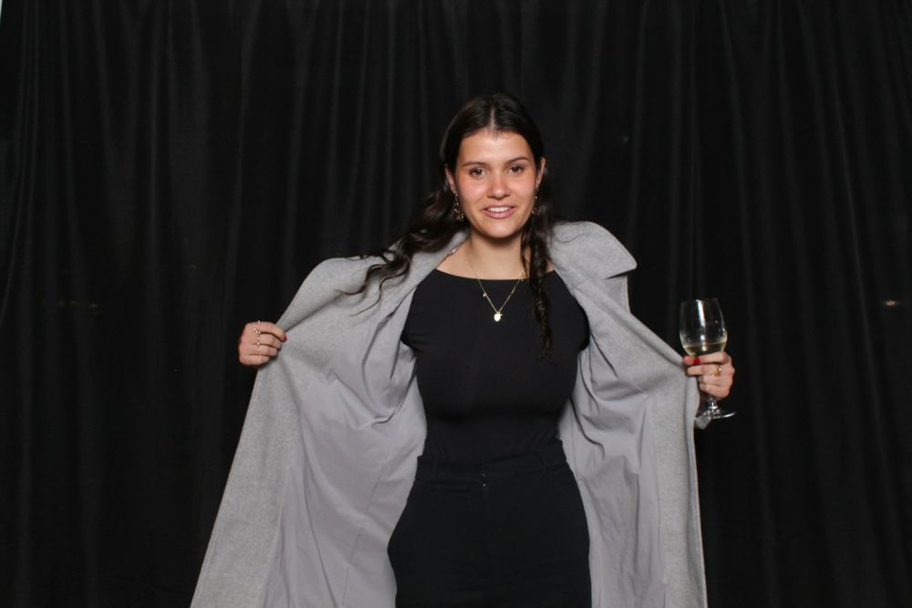 Guest posing in front of a black photo booth backdrop